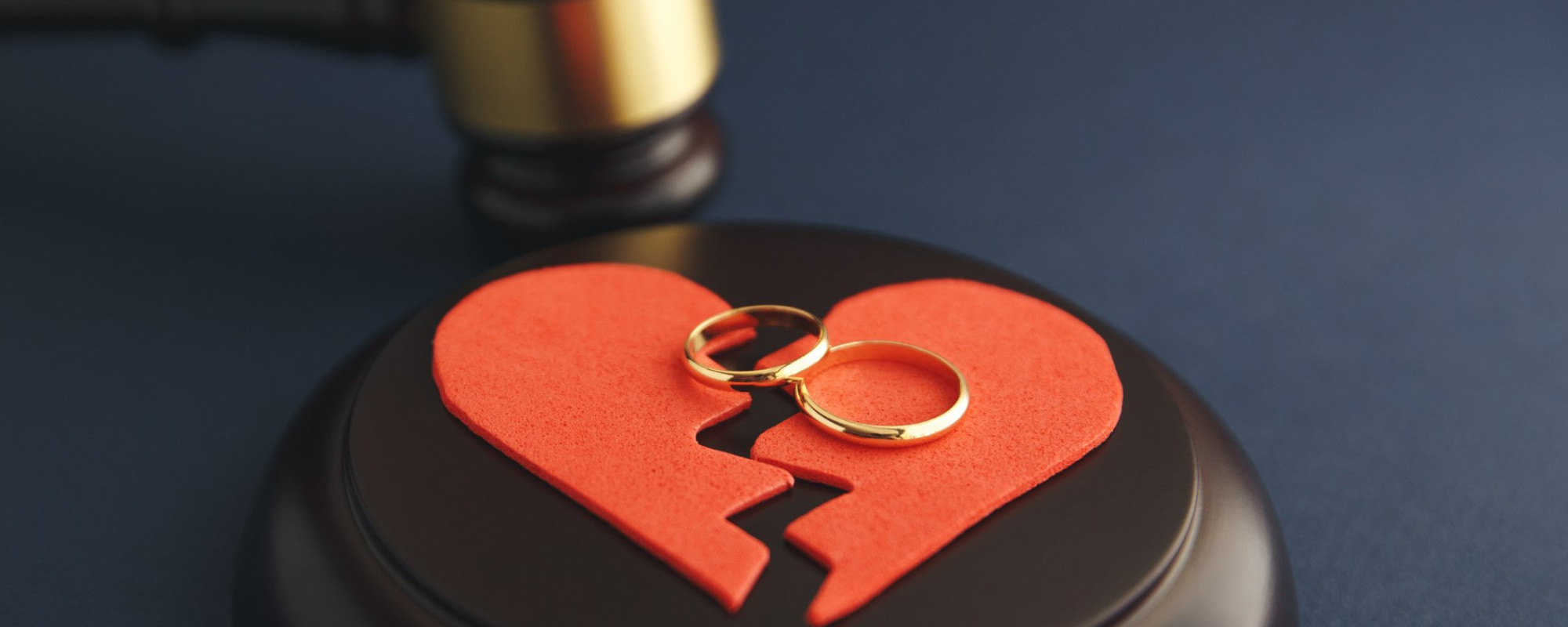 An image of a gavel and rings and a broken heart symbolizing divorce proceedings